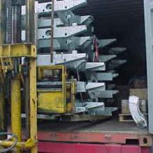 A stack of new Land Rover chassis being loaded into a shipping container  for USA