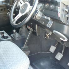 The picture shows the driver side of the dashboard and steering wheel of the defender