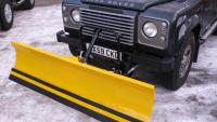 HERE IS A SNOW PLOUGH ON THE FRONT OF A LAND ROVER DEFENDER 